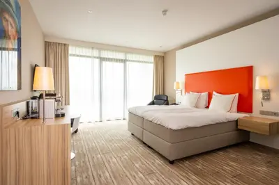 a hotel room with a bed and a large window at Van der Valk Hotel Schiphol in Hoofddorp