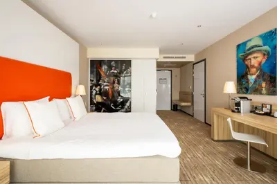 a hotel room with a large bed and a desk at Van der Valk Hotel Schiphol in Hoofddorp