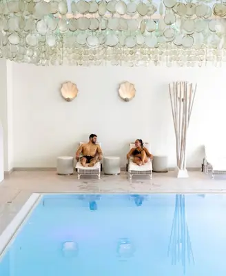 two men sitting in chairs next to a swimming pool at Van der Valk Hotel Vianen - Utrecht in Vianen