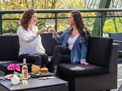 two women sitting on a chair drinking wine at Van der Valk Hotel Vianen - Utrecht in Vianen