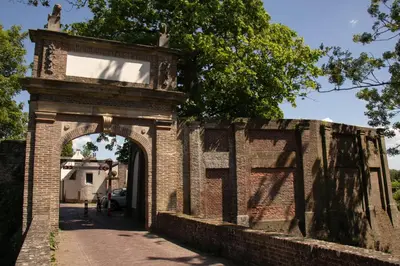 an old brick wall with an archway on a street at Van der Valk Hotel Vianen - Utrecht in Vianen