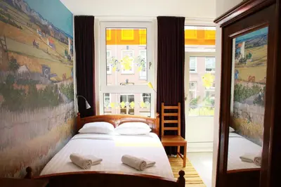 a bedroom with a bed and a window at Bicycle Hotel Amsterdam in Amsterdam