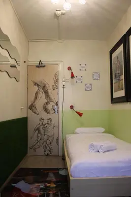a room with two beds and a painting on the wall at Bicycle Hotel Amsterdam in Amsterdam