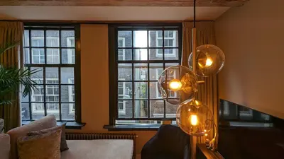 a living room with windows and a chandelier at Locatie Downtown in Amsterdam