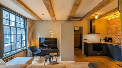 a kitchen and living room with a couch and a table at Locatie Downtown in Amsterdam