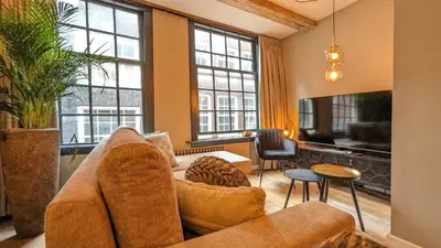 a living room with a couch and some windows at Locatie Downtown in Amsterdam
