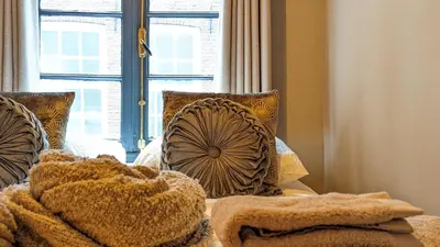a bedroom with a bed with pillows and a window at Locatie Downtown in Amsterdam