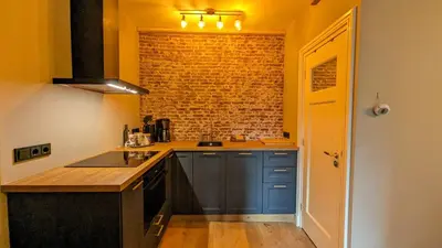 a kitchen with blue cabinets and a brick wall at Locatie Downtown in Amsterdam