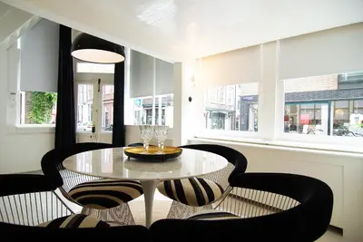 a dining room with a table and chairs and windows at Exceptional Stay in Jordaan Area in Amsterdam