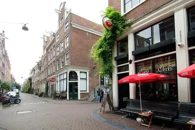 a street with a bench and an umbrella in front of a store at Exceptional Stay in Jordaan Area in Amsterdam