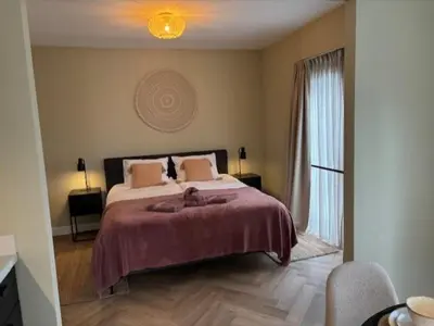 a bedroom with a large bed and a window at The Oyster House With Private Parking in Zandvoort