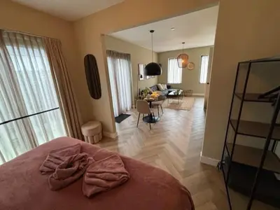 a bedroom with a bed and a living room at The Oyster House With Private Parking in Zandvoort