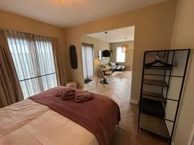 a bedroom with a bed and a living room at The Oyster House With Private Parking in Zandvoort