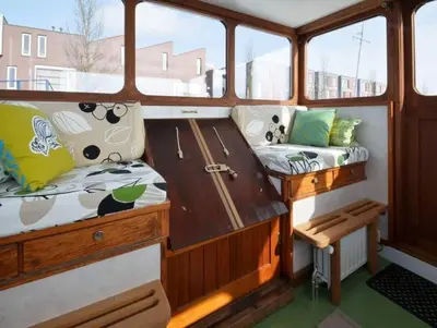 a boat with two seats on the side of it at Houseboat Captain's Quarters in Harbour Amsterdam in Amsterdam