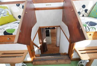 a tiny house with a staircase in a bedroom at Houseboat Captain's Quarters in Harbour Amsterdam in Amsterdam