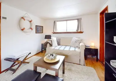 a living room with a couch and a table at Houseboat Captain's Quarters in Harbour Amsterdam in Amsterdam