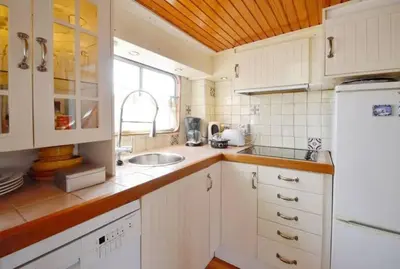 a kitchen with white cabinets and a sink at Houseboat Captain's Quarters in Harbour Amsterdam in Amsterdam