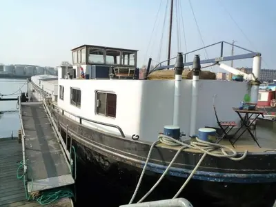 a boat docked at a dock in the water at Houseboat Captain's Quarters in Harbour Amsterdam in Amsterdam
