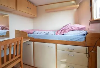 a small bedroom with a bunk bed and a crib at Houseboat Captain's Quarters in Harbour Amsterdam in Amsterdam