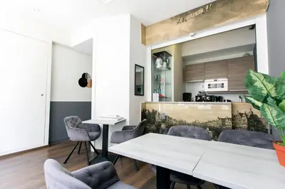 a kitchen and dining room with a table and chairs at Quentin Leidse Square Hotel in Amsterdam
