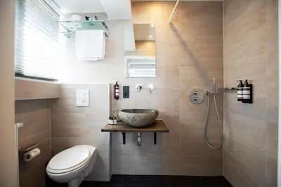a bathroom with a sink and a toilet and a shower at Quentin Leidse Square Hotel in Amsterdam