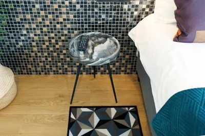 a cat sleeping in a basket next to a bed at Quentin Leidse Square Hotel in Amsterdam