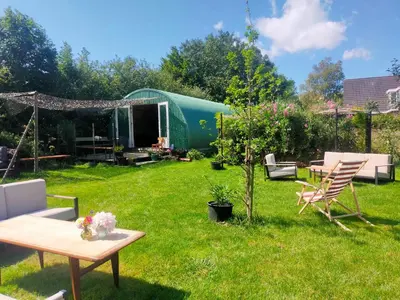 a garden with a tent and a table and chairs at De Groote Wijzend in Lutjebroek