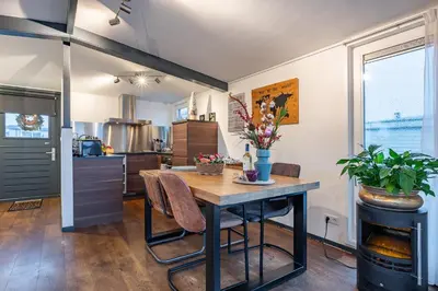 a kitchen and dining room with a table with flowers on it at Watervillashiraz in Aalsmeer