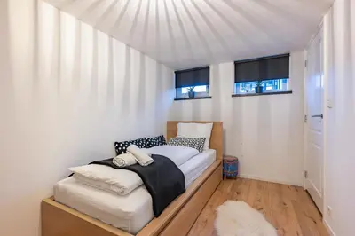 a bedroom with a bed and two windows at Watervillashiraz in Aalsmeer