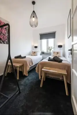 a bedroom with two beds and a table in it at Cozy 2-bedroom apartment in Amsterdam