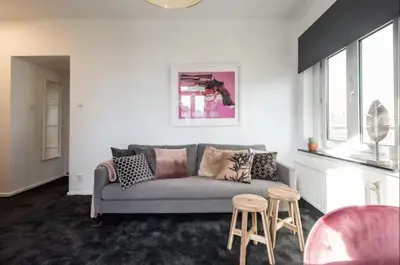 a living room with a gray couch and two stools at Cozy 2-bedroom apartment in Amsterdam