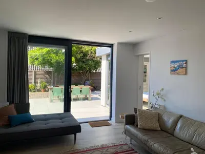 a living room with a couch and a sliding glass door at White Sand Beach in Bergen aan Zee