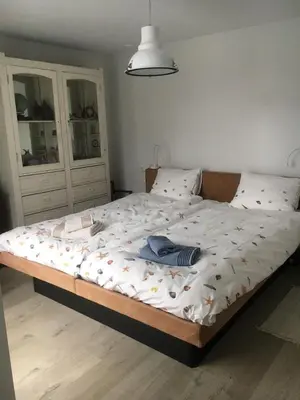 a bedroom with a bed with a blanket on it at White Sand Beach in Bergen aan Zee