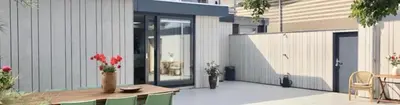 a patio with a table and chairs and a building at White Sand Beach in Bergen aan Zee