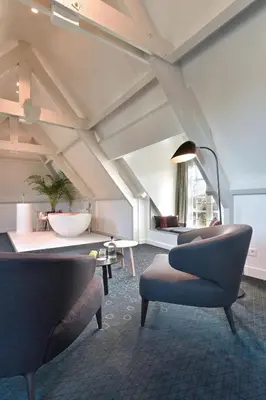 a living room with two chairs and a lamp at De Nederlanden, Restaurant & Boutique Hotel in Vreeland
