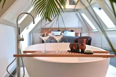 a table with two glasses and a tray with a drink at De Nederlanden, Restaurant & Boutique Hotel in Vreeland