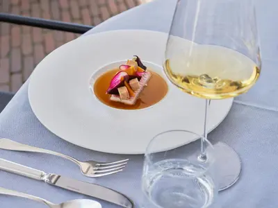 a plate of food and a glass of wine on a table at De Nederlanden, Restaurant & Boutique Hotel in Vreeland