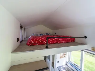 a bed in a small room with a window at Holiday home in Burgerbrug near the beach in Burgerbrug