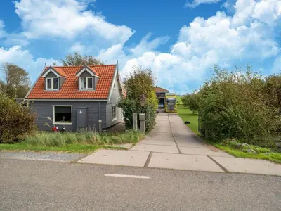a house with an orange roof on a street at Holiday home in Burgerbrug near the beach in Burgerbrug