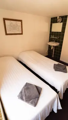 two twin beds in a room with a mirror at Hotel Internationaal in Amsterdam
