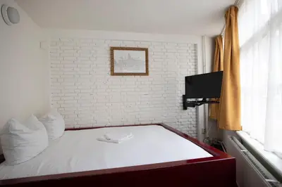 a bed in a room with a white brick wall at Hotel Internationaal in Amsterdam