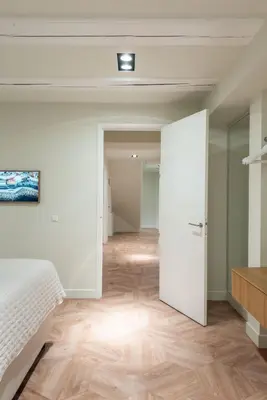 a bedroom with a white bed and a wooden floor at Newly renovated luxurious 200 SQM loft in city centre in Amsterdam