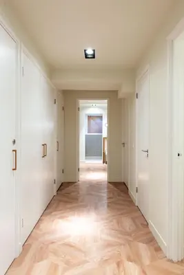 an empty hallway with white doors and wooden floors at Newly renovated luxurious 200 SQM loft in city centre in Amsterdam