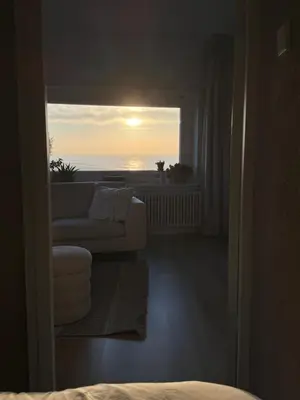 a living room with a couch and a view of the ocean at Sea La Vie- Appartement aan het strand in Zandvoort aan Zee! in Zandvoort