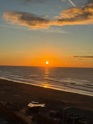 a sunset on the beach with the ocean at Sea La Vie- Appartement aan het strand in Zandvoort aan Zee! in Zandvoort
