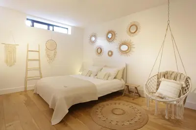 a bedroom with a swing bed and a chair at Villa M in Schoorl