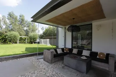 a living room with a couch on a patio at Villa M in Schoorl