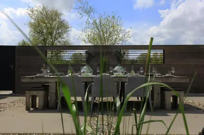 a table with glasses on it in a garden at Villa M in Schoorl