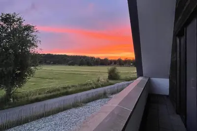 a view of a sunset from a balcony of a house at Villa M in Schoorl