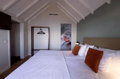 a bedroom with a large bed with white sheets and orange pillows at Hotel Spaander BW Signature Collection in Volendam